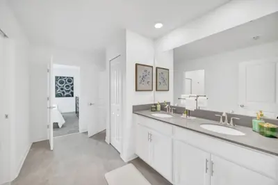 a white bathroom with two sinks and a mirror at Modern 9 Bedroom Oasis for Large Groups 6272 in Kissimmee