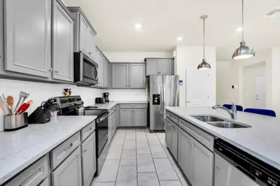 a kitchen with white cabinets and stainless steel appliances at Elegant Villa for Large Groups 6281 in Kissimmee