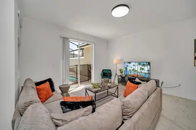 a living room with a large couch with orange pillows at Cozy 4 Bedroom Urban Oasis 6326 in Kissimmee