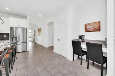 a kitchen with white cabinets and a table and chairs at Elegant Villa Retreat with Private Pool 6328 in Kissimmee