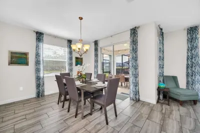 a dining room with a table and chairs at 6 Bedroom Villa with Tennis Court Gym 6332 in Kissimmee