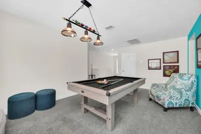a room with a pool table and a chair at 6 Bedroom Villa with Tennis Court Gym 6332 in Kissimmee
