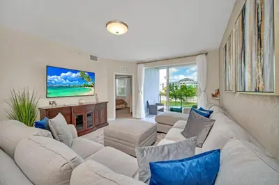 a living room with a large white couch and blue pillows at Chic Urban Oasis with 3 Bedrooms 6333 in Kissimmee