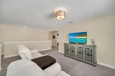 a living room with a white couch and a flat screen tv at Modern Villa with Game Room Theater 6334 in Kissimmee