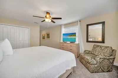 a bedroom with a bed and a couch and a ceiling fan at Modern Villa with Game Room Theater 6334 in Kissimmee