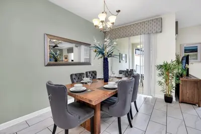a dining room with a wooden table and chairs at Modern 4 Bedroom Villa near Beach Shopping 6335 in Kissimmee