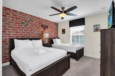 a bedroom with two beds and a brick wall at Modern 4 Bedroom Villa near Beach Shopping 6335 in Kissimmee
