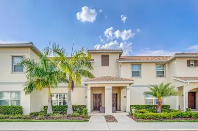 a house with palm trees in front of it at Your Ultimate Vacation Getaway 6336 in Kissimmee