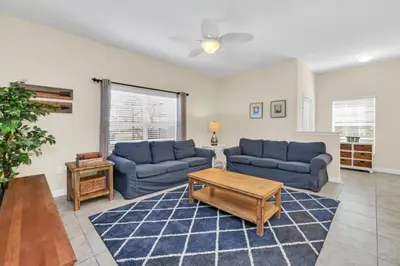 a living room with two blue couches and a table at Spacious 5 Bedroom Villa for Families 6337 in Kissimmee