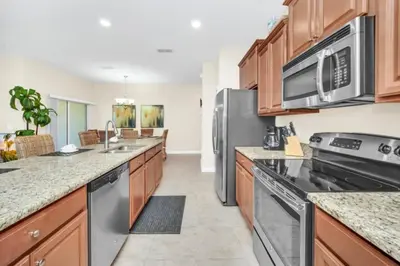 a kitchen with stainless steel appliances and wooden cabinets at Tranquil Villa Retreat with Mountain Views 6338 in Kissimmee