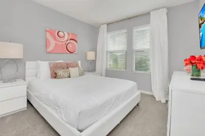 a white bedroom with a white bed and a window at Cozy 4BR Cottage with Fireplace 6379 in Kissimmee