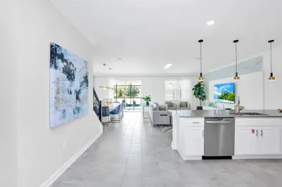a kitchen and living room with white cabinets at Spacious Villa Retreat with 9 Bedrooms 6381 in Kissimmee