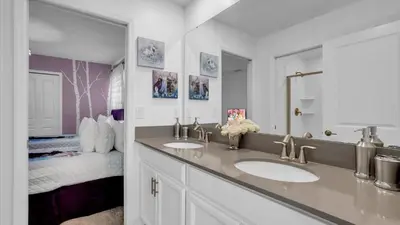 a bathroom with two sinks and a bed at Rent the Perfect 8 Bedroom Villa on Storey Lake Resort Orlando Villa 6293 in Kissimmee