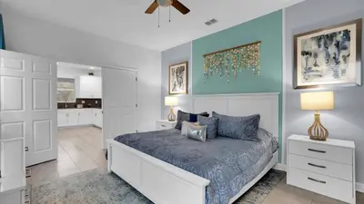 a bedroom with a bed with a blue wall at Rent the Perfect 8 Bedroom Villa on Storey Lake Resort Orlando Villa 6293 in Kissimmee