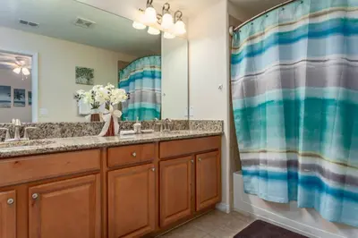 a bathroom with two sinks and a large mirror at Rent this Luxury 5 Star Townhome on Paradise Palms Resort Orlando Townhome 6299 in Kissimmee