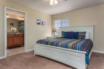 a bedroom with a white bed and a bathroom at Rent this Luxury 5 Star Townhome on Paradise Palms Resort Orlando Townhome 6299 in Kissimmee