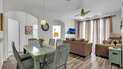 a dining room and living room with a table and a couch at Orlando Condo 6420: Family-Friendly Resort Near Disney in Kissimmee