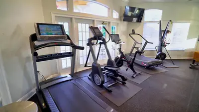 a gym with exercise bikes and a laptop on a treadmill at 5-Star Orlando Townhome 6423 - Resort Amenities Near Disney in Kissimmee