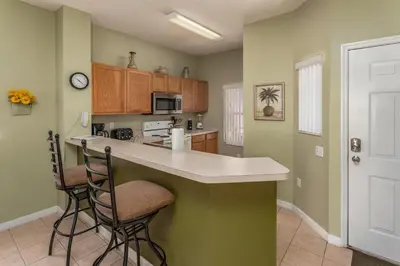 a kitchen with a counter and two stools at Orlando 6424 Townhome: Family Fun Close to Disney in Kissimmee