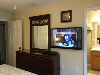 a tv on a wall in a bedroom at Luxury Orlando Townhome 6425 - Emerald Island Resort Stay in Kissimmee