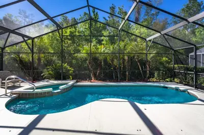 a swimming pool in a glass house with a swimming poolvisor at Orlando Villa 6426: Cumbrian Lakes Pool Spa Retreat in Kissimmee