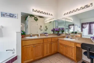 a bathroom with two sinks and a large mirror at Orlando Villa 6426: Cumbrian Lakes Pool Spa Retreat in Kissimmee