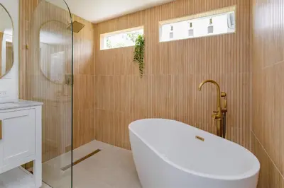 a bathroom with a tub and a glass shower at Orlando Home 6430: Purpose-Driven A-Frame Vacation Home in Clermont