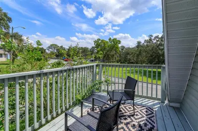 a porch with two chairs and a fence at Orlando Home 6430: Purpose-Driven A-Frame Vacation Home in Clermont