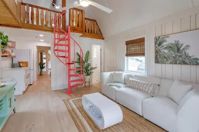 a living room with a white couch and a red staircase at Orlando Home 6430: Purpose-Driven A-Frame Vacation Home in Clermont