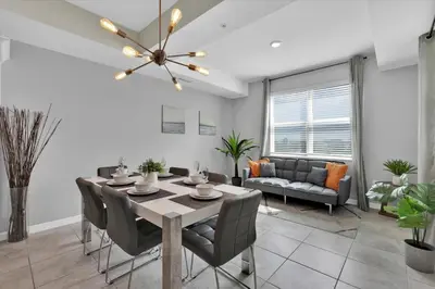 a dining room and living room with a table and chairs at Book Now: Orlando Condo 6439 at Storey Lake Resort in Kissimmee