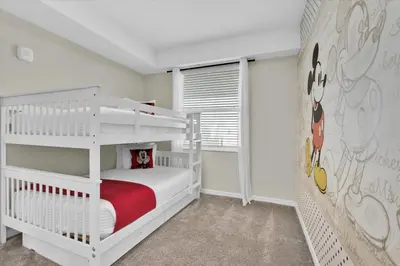 a white bedroom with a bunk bed and a ladder at Book Now: Orlando Condo 6439 at Storey Lake Resort in Kissimmee