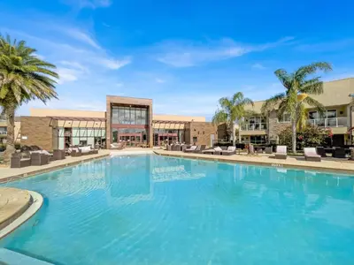 a large swimming pool with palm trees and buildings at Book Now: Orlando Townhome 6440 Near Disney Magic in Orlando