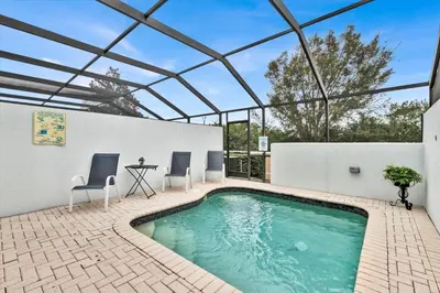 an indoor swimming pool with two chairs and a table at Orlando Townhome 6442 - Private Pool Club Access in Orlando
