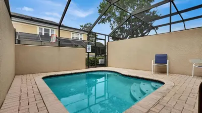 a swimming pool with a chair and a house at Orlando Townhome 6443: Family Fun Near Disney in Orlando