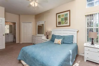 a bedroom with a bed with a blue comforter at Stay Near Disney at Orlando Townhome 6444 Sleeps 8 in Kissimmee