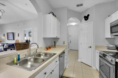 a kitchen with white cabinets and a sink at Orlando Condo 6445: Family Fun Near Disney in Kissimmee