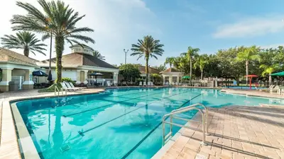 a swimming pool at a resort with palm trees at Orlando Condo 6445: Family Fun Near Disney in Kissimmee