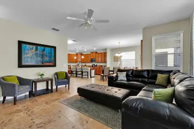 a living room with a leather couch and a dining room at 5-Star Orlando Villa 6452: Family Fun Resort Access in Kissimmee