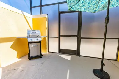 a kitchen with a stove and an umbrella in a room at Orlando Townhome 6453: Your Private Pool Getaway in Kissimmee
