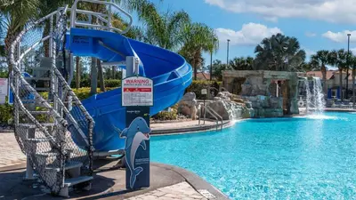 a dolphin water slide in a pool at a resort at Orlando Townhome 6453: Your Private Pool Getaway in Kissimmee