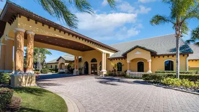 a large yellow house with a driveway at Orlando Townhome 6453: Your Private Pool Getaway in Kissimmee