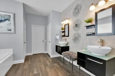 a bathroom with two sinks and a mirror at Orlando Villa 6469: 6BR Home Near Disney Parks in Kissimmee