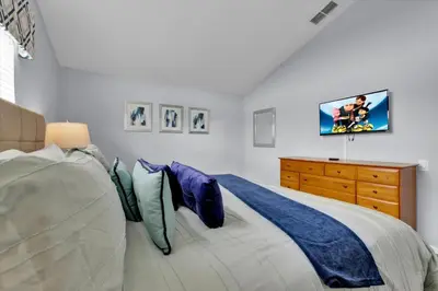 a bedroom with a bed and a tv on the wall at Orlando Villa 6469: 6BR Home Near Disney Parks in Kissimmee