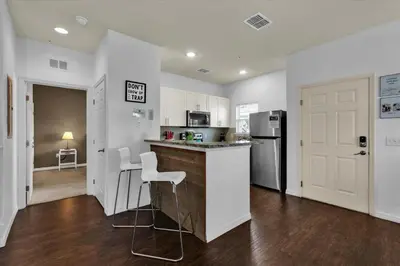 a kitchen with white cabinets and a counter with stools at Orlando Townhome 6458: Perfect Base for Your Disney Trip in Kissimmee
