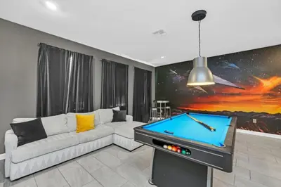 a living room with a couch and a pool table at You and Your Family will Love this Luxury Villa on Storey Lake Resort Orlando Villa 6295 in Kissimmee