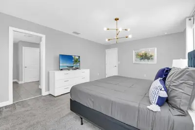 a bedroom with a bed and a flat screen tv at You and Your Family will Love this Luxury Villa on Storey Lake Resort Orlando Villa 6295 in Kissimmee
