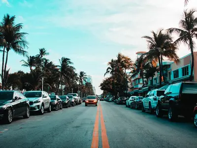 a car is driving down a street with parked cars at Picture Renting Your Own Luxury Villa on the Exclusive Paradiso Grande Resort close to Disney Orlando Villa 6402 in Orlando