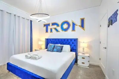 a bedroom with a blue bed with the iron sign on the wall at Orlando Villa 6227: The Secret to Your Dream Resort Holiday in Kissimmee