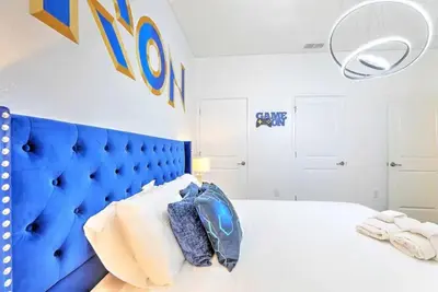 a bedroom with a blue headboard and a white bed at Orlando Villa 6227: The Secret to Your Dream Resort Holiday in Kissimmee