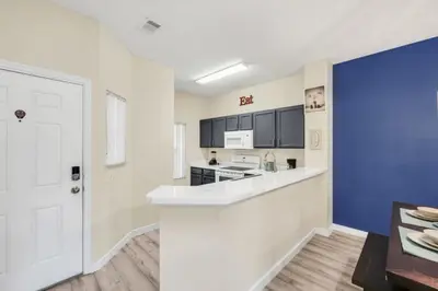 a kitchen with white counters and a blue wall at Orlando Villa 6230: A Stylish Family Retreat Near Disney in Kissimmee
